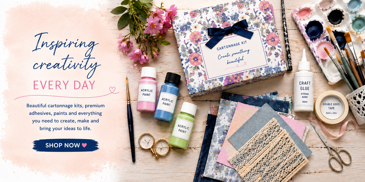 Crafting supplies including paint, brushes, and a cartoon kit on a wooden surface with flowers.