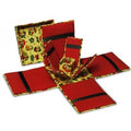 A set of red and yellow patterned fabric coasters with black stripes, shown both folded and unfolded on a white background.