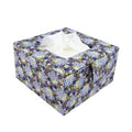 Floral-patterned tissue box with tissues inside on a white background.