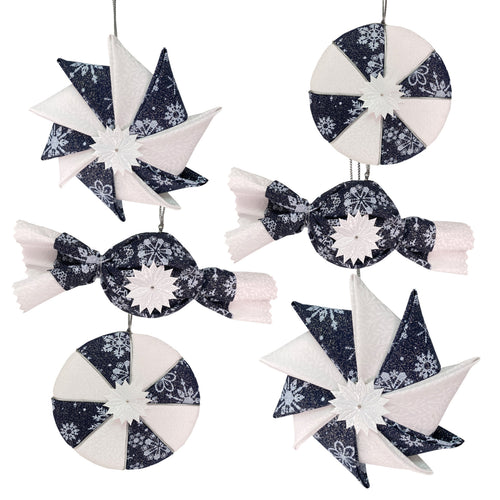 A set of six navy blue and white fabric Christmas ornaments shaped like candy, stars, and pinwheels, arranged on a plain white background.
