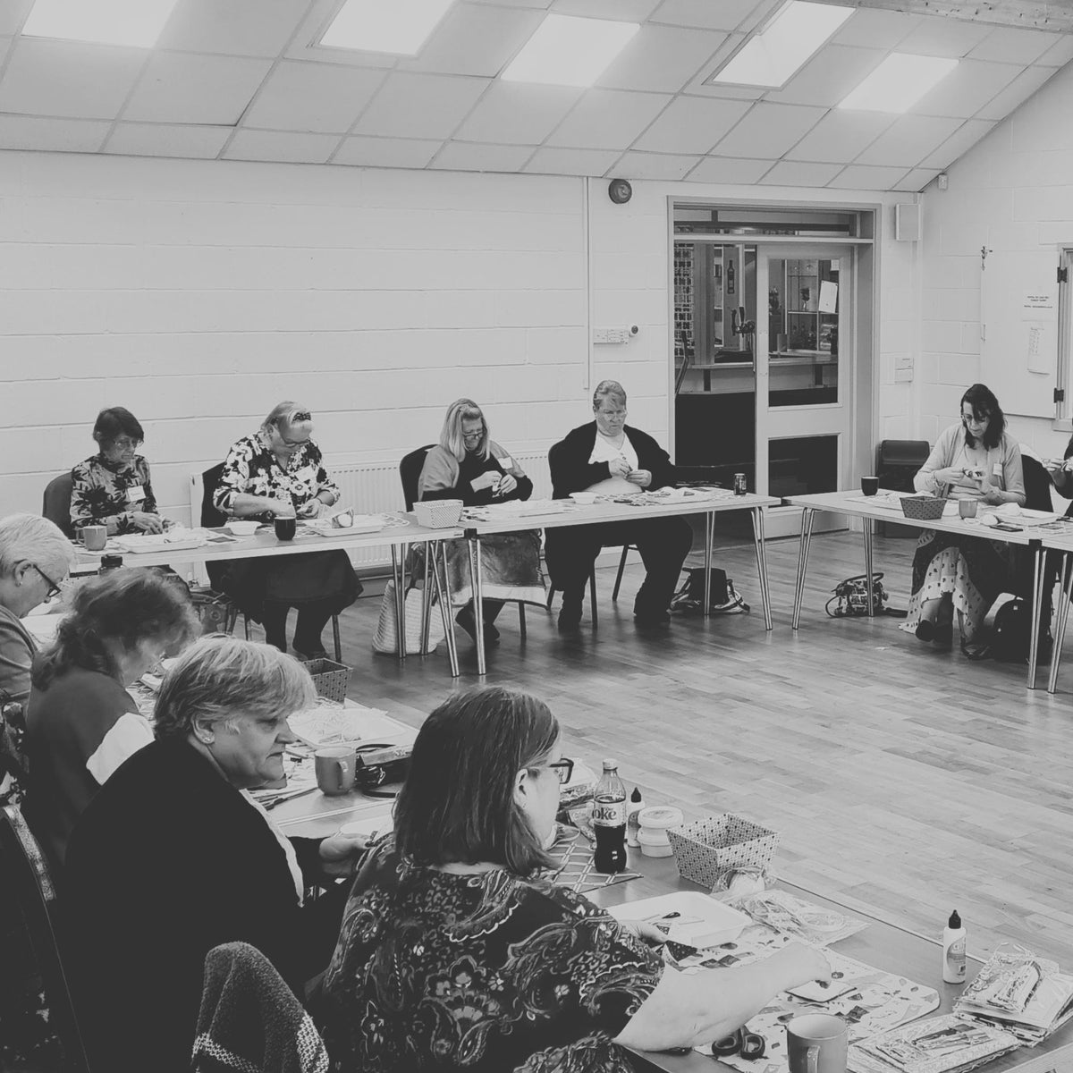 Group of people sitting around tables undertaking an activity.