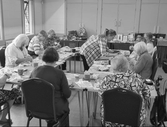 Group of people sitting around a table in a classroom setting.